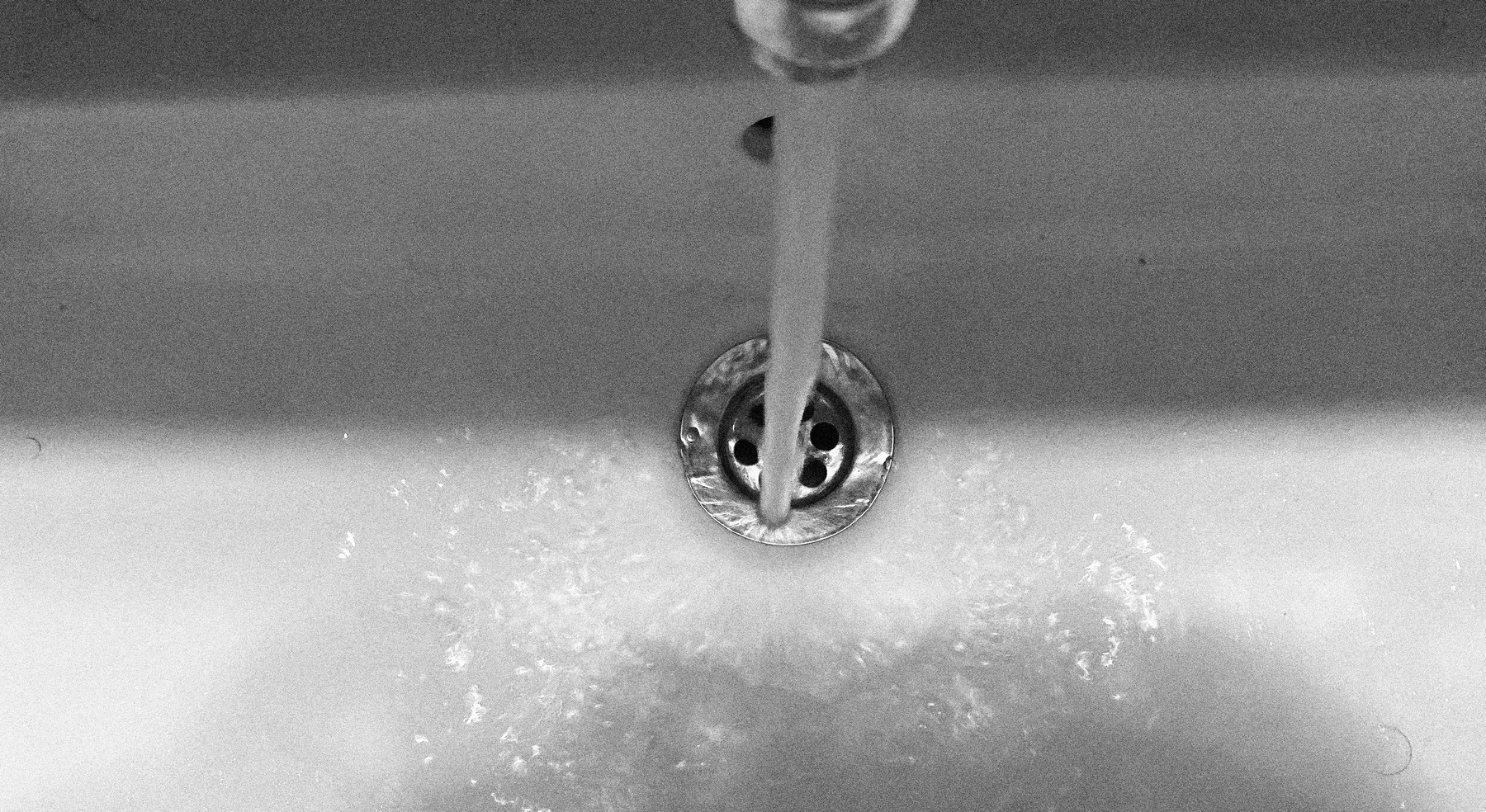 Wasser läuft langsam in einen Küchenabfluss