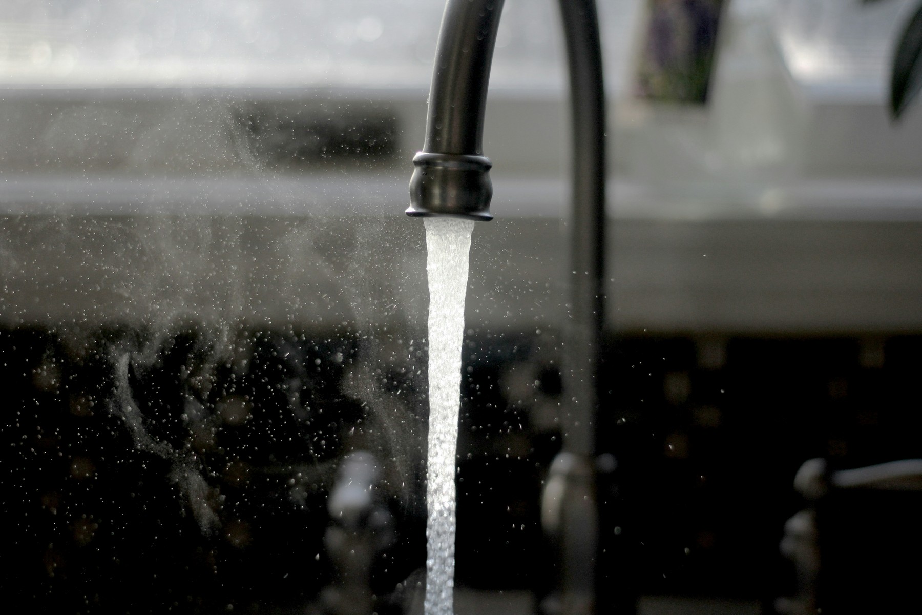 Heißes Wasser läuft in eine Küchenspüle
